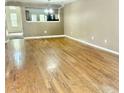 Spacious living room with shiny hardwood floors and an open concept design with neutral paint color at 5226 Fernland Way, North Charleston, SC 29420