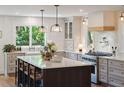 Bright, airy kitchen featuring a large center island, modern appliances, and views to the backyard at 595 Crowned Kinglet Retreat, Charleston, SC 29412