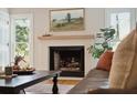 Cozy living room with a classic fireplace, mantle, and inviting natural light at 595 Crowned Kinglet Retreat, Charleston, SC 29412