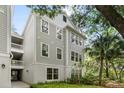 Three-story building featuring light gray siding and white trim, complemented by lush landscaping and a picturesque tree line at 60 Fenwick Hall Allee # 321, Johns Island, SC 29455