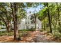 Beautiful three-story home with light gray siding surrounded by lush greenery and mature trees, creating a serene setting at 60 Fenwick Hall Allee # 321, Johns Island, SC 29455