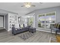 Comfortable living room with stylish gray sofa, built-in bookshelves, and natural light from the windows at 700 Daniel Ellis Dr # 10307, Charleston, SC 29412