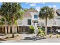 Charming stilted home boasts updated siding and trim and is framed by mature palms and landscaped grounds at 732 Spinnaker Beachhouse, Seabrook Island, SC 29455