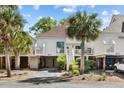 Charming stilted home boasts updated siding and trim and is framed by mature palms and landscaped grounds at 732 Spinnaker Beachhouse, Seabrook Island, SC 29455