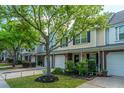 Street view showcasing well-maintained townhomes and mature trees at 8652 Grassy Oak Trl, North Charleston, SC 29420