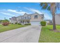 Traditional two-story home with a driveway, complemented by a green lawn and mature tree at 9379 Harroway Rd, Summerville, SC 29485