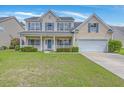 Inviting two-story home with a classic facade, complemented by lush green lawn at 9379 Harroway Rd, Summerville, SC 29485