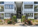 Exterior view of gated entry to condo building with manicured landscaping and colorful roses at 1025 Riverland Woods Pl # 1008, Charleston, SC 29412