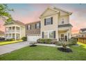 Home featuring manicured lawn, mulched garden, brick and siding facade, and concrete driveway leading to attached garage at 103 Radtko Rd, Summerville, SC 29486