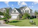 Two-story home with dark roof, light siding, attached garage, landscaping, and green grass at 104 Valentin Dr, Summerville, SC 29483