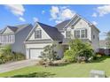 Two-story home with dark roof, light siding, landscaping, green lawn, and attached garage at 104 Valentin Dr, Summerville, SC 29483