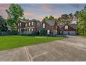 Lovely brick two-story home with a manicured lawn, long driveway, attached three-car garage, and blooming flowers at 105 Birkbeck Ct, Goose Creek, SC 29445