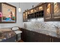 Elegant bar area with granite countertops, mosaic backsplash, wine rack and custom cabinets at 108 Bluff Isle Ct, Summerville, SC 29486