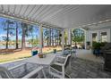Covered outdoor patio with stone flooring, offering scenic views of the lake and surrounding trees at 108 Bluff Isle Ct, Summerville, SC 29486