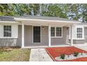 Welcoming front porch with painted brick columns and trim, offering a cozy and shaded entrance to the home at 108 Wadmalaw Cir, Summerville, SC 29483
