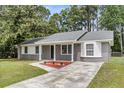 Inviting home showcasing neat landscaping, gray brick, and white trim, creating a welcoming and well-maintained exterior at 108 Wadmalaw Cir, Summerville, SC 29483