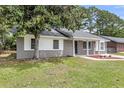 Charming home with a spacious front yard, mature trees, and a brick facade, blending natural beauty with classic architecture at 108 Wadmalaw Cir, Summerville, SC 29483