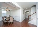Elegant dining room featuring wainscoting, hardwood floors, chandelier and staircase to the second floor at 1146 Moss Grove Dr, Moncks Corner, SC 29461
