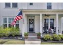 Inviting front porch with flag, seating, and a beautifully decorated door at 116 Backhurst Dr, Summerville, SC 29486
