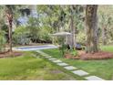 Secluded backyard featuring a sparkling pool, a cozy pavilion, and lush greenery for ultimate relaxation at 126 Sparrow Dr, Isle of Palms, SC 29451