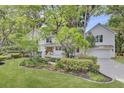 Beautiful white house featuring a lush green lawn, manicured landscaping, and a welcoming front porch at 126 Sparrow Dr, Isle of Palms, SC 29451
