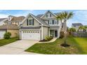 Beautiful two-story home with well-maintained lawn, attached garage, complemented by a mature palm tree at 1426 Tannery Row, Johns Island, SC 29455