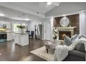 Cozy living room with a brick fireplace, modern furnishings, open layout to kitchen, and hardwood floors at 166 Braly Dr, Summerville, SC 29485