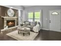 Comfortable living room featuring a brick fireplace, grey sofa, ottoman, and a white door, ideal for relaxation at 166 Braly Dr, Summerville, SC 29485