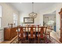 Elegant dining room featuring a chandelier, decorative wallpaper, and an adjacent kitchen view at 2408 Bending Oak Loop, Mount Pleasant, SC 29466