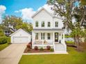 Charming two-story home with white siding, a inviting front porch and a detached garage at 2815 Colonel Harrison Dr, Johns Island, SC 29455