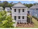 Two-story white home featuring a double-decker porch and professional landscaping at 2866 Sugarberry Ln, Johns Island, SC 29455