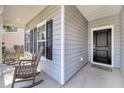 Inviting front porch with rocking chairs and an entrance with black door at 3431 Great Egret Dr, Johns Island, SC 29455