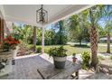 Inviting front porch with brick flooring, lush landscaping, and a cozy seating area, perfect for relaxing and enjoying the view at 356 Hobcaw Dr, Mount Pleasant, SC 29464