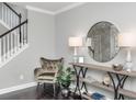 Stylish foyer showcasing a decorative table with a round mirror and comfortable chair near the staircase at 4906 W Liberty Park Cir, North Charleston, SC 29405