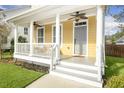 Close-up of a welcoming front porch featuring white columns, a gray door, and a cozy seating area at 4906 W Liberty Park Cir, North Charleston, SC 29405
