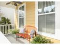 Inviting front porch with comfortable seating, decorative pillows, and potted plants for a cozy outdoor space at 4906 W Liberty Park Cir, North Charleston, SC 29405