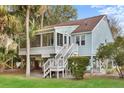 Lovely exterior view of a raised home with light blue siding and mature trees at 507 Cobby Creek Ln, Seabrook Island, SC 29455