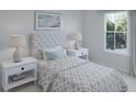 Bright bedroom featuring a cozy bed, stylish nightstands, and a window overlooking lush greenery at 581 Red Monarch Way, Moncks Corner, SC 29461