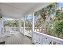 Relaxing covered porch with a rocking chair and scenic views of lush greenery at 67 Lost Village Trl # 8, Edisto Island, SC 29438