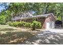 View of a beautiful brick house with a two car garage surrounded by mature trees at 679 Edmonds Dr, Charleston, SC 29412