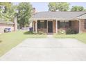 A beautiful home with a well-manicured lawn and a paved driveway at 7712 Corley Dr, North Charleston, SC 29418
