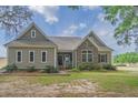 Charming home featuring a combination of stone and siding, complemented by lush landscaping at 7875 Berry Manor Ln, Edisto Island, SC 29438