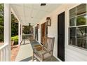 Inviting front porch featuring classic rocking chairs, wood flooring, and a charming wooden door at 930 Richter Way, Mount Pleasant, SC 29464