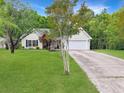 Inviting home with lush green lawn and an attached garage, showcasing curb appeal at 1061 Reverend Joseph Heyward Rd, Charleston, SC 29414