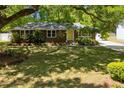 Charming brick home nestled on a verdant lawn, surrounded by mature trees and inviting curb appeal at 1172 Dawn Dr, Charleston, SC 29412