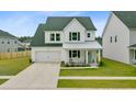 Inviting two-story home with a well-kept lawn, attached garage, and a charming front porch at 1226 Spotflower St, Summerville, SC 29485