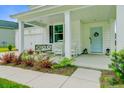 Charming front porch with a swing, rocking chairs, a blue door, and decorative plants at 1226 Spotflower St, Summerville, SC 29485