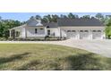 Side view of a white home featuring a three-car garage and lush landscaping at 1245 Saddlehorn Rd, Summerville, SC 29486