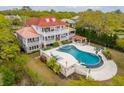 Aerial view of a sprawling home with a red roof, multiple balconies, a large pool, and lush landscaping at 13 Broughton Rd, Charleston, SC 29407