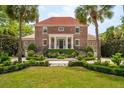 A beautiful brick home boasts symmetrical staircases, mature landscaping, and a classic architectural style at 13 Broughton Rd, Charleston, SC 29407